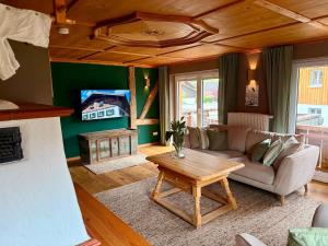 普夫龙滕FeWo Pfronten - Berge und Bilder OG的客厅里有一张沙发和一张桌子。