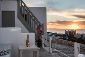 a balcony with a table and a bottle of wine at Christy Suites by Alpha Living in Mikonos