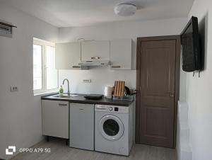a kitchen with a washing machine and a washer at Marea Albastră in Eforie Sud