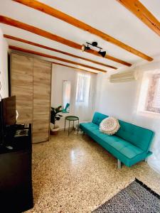 a living room with a blue couch and a table at Πέτρινο σπίτι δίπλα στη θάλασσα in Votsalákia