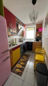 kuchnia z czerwoną i żółtą szafką oraz zlewem w obiekcie Rodenkirchen Living w Kolonii