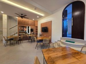 a dining room and kitchen with tables and chairs at The Polle Canggu in Badung