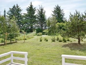 two white benches in a field with trees at 6 person holiday home in Fjerritslev-By Traum in Fjerritslev