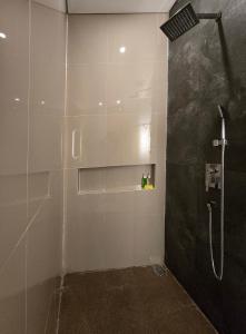 a bathroom with a shower with a shower head at The Polle Canggu in Badung +32 photos