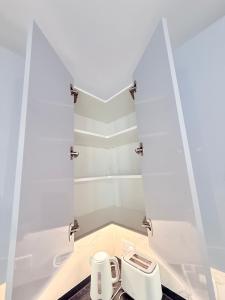 a small kitchen with white walls and a toaster at E1 Simple Apartment in Gibraltar +26 photos