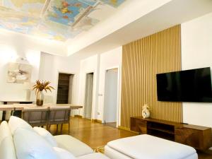 a living room with a couch and a tv on a wall at INTOMILAN I Design Apartment in the Heart of Milan in Milan