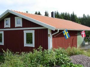 a red house with flags on the side of it at 8 person holiday home in GRÄNNA-By Traum in Målskog