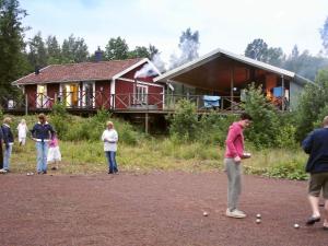 a group of people playing dominoes in front of a house at 8 person holiday home in GRÄNNA-By Traum in Målskog