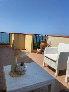 un patio con 2 sillas, una mesa y un sofá en Eolie all'orizzonte, en Capo dʼOrlando
