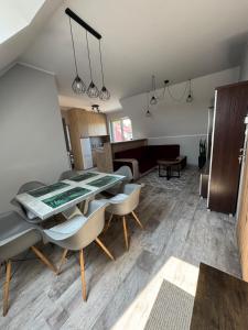 a living room with a dining table and chairs at Apartament przy Lesie - Domki u Piotrusia in Żarnowska