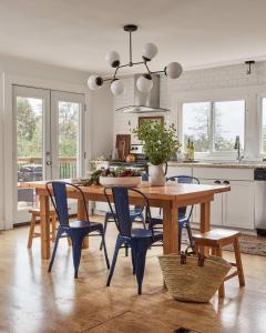 WaupoosにあるGran Roble - Charming Countryside Retreatのキッチン(木製テーブル、青い椅子付)