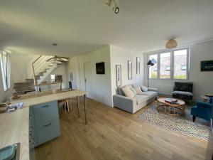 プルゴンヴランにあるMaison de vacances à pied de la plage du Trez Hir - confort, calme & océanのソファとテーブルのあるキッチンとリビングルーム
