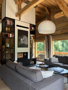 a living room with a gray couch and a table at Ferme des Tétras - Chalet de prestige en montagne in Saint-Gervais-les-Bains