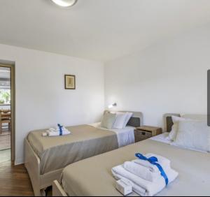 Dos camas en una habitación con toallas encima. en La Casa Fra gli Ulivi luxury apartments with pool near Cinque Terre and Tuscany, en Monte Marcello 61 fotos más