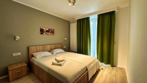 a bedroom with a bed and a window with green curtains at Timisoara Prime Residence - powered by NEO - private parking in Timişoara