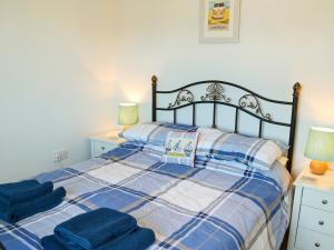 a bedroom with a bed with blue towels on it at Captain Ron's in Beadnell
