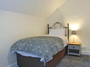 a bedroom with a bed and a lamp on a table at Halleaths Home Farm in Lochmaben +5 photos