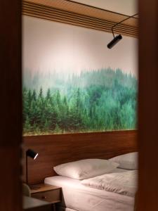 two beds in a room with a picture of a forest at OW Sudety in Szklarska Poręba