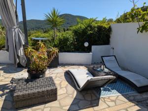 a patio with a couch and chairs on a patio at Beautiful Provencal villa in Les Adrets de l'Esterel