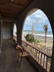 a porch with chairs and a view of the beach at The Beachbreaks Medewi in Airsatang