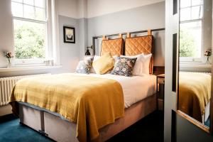 a bedroom with two beds and two windows at The Queen's Head in Kingston upon Thames