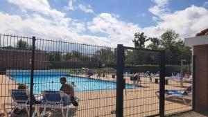a group of people sitting in chairs near a swimming pool at Holiday Home 'Rietvogel' in Herkingen