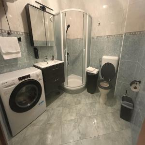 a bathroom with a washing machine and a toilet at Adriatic Oasis Apartments in Preko