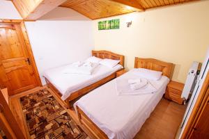 two beds in a small room with wooden floors at Casa Albă in Baia de Aramă +92 photos