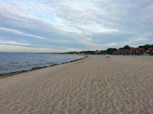 ソポトにあるSopot kawalerka 200m od morzaの砂浜と水上を歩く人々のいる浜