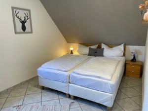 een slaapkamer met een wit bed en een nachtkastje bij Ferienhaus in Elend in Elend