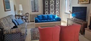 a living room with two chairs and a blue couch at Residenza Rosmarino CASA GUARNONE in Mornico Losana