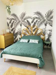 1 dormitorio con cama verde y papel pintado tropical en Very nice house 2 steps from the beach, en La Tranche-sur-Mer