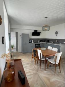 Una cocina y un comedor con mesa y sillas. en Very nice house 2 steps from the beach, en La Tranche-sur-Mer