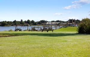 un parco con tavoli da picnic sull'erba vicino all'acqua di Stunning Home In Gråsten With Sauna a Gråsten Altre 18 foto