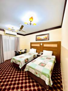 a hotel room with two beds and a ceiling at Al Ahrar Hotel in Dubai +34 photos