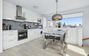 a kitchen with white cabinets and a table with chairs at Seebär in Olpenitz