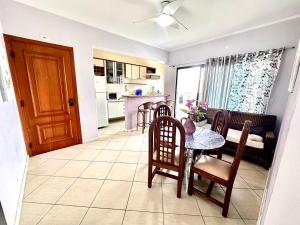 a kitchen and dining room with a table and chairs at 1 Flats Capitania Varan, Wifi, Pitangueiras vista ao mar in Guarujá