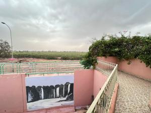 a painting on the side of a wall next to a fence at Élégante Villa 3 Chambres avec Jardin & Piscine Targa Afak Marrakech in Marrakech