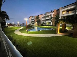 a building with a swimming pool in the middle of a park at TerraMaris - Aptos vista mar, pe na areia, vizinho ao B Park in Aquiraz