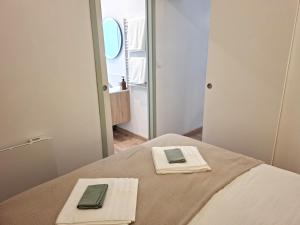 a bedroom with a bed with two towels and a mirror at Le Cocon de Charme - 4pers - 2min Halle Marcadieu - 6min centre ville in Tarbes +22 photos