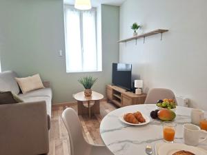 a living room with a table with food on it at Le Cocon de Charme - 4pers - 2min Halle Marcadieu - 6min centre ville in Tarbes