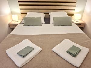 a large white bed with two pillows on it at Le Cocon de Charme - 4pers - 2min Halle Marcadieu - 6min centre ville in Tarbes