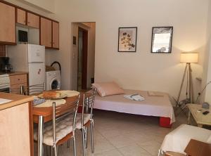 a kitchen with a table and a bed in a room at Olga's House in Preveza