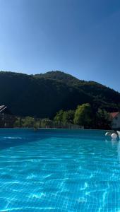 a large blue swimming pool with a mountain in the background at Trembita in Mizhhirʼʼya