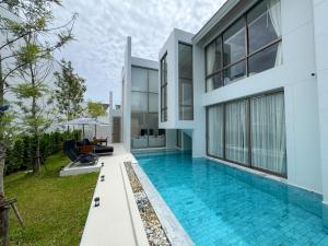 an exterior view of a house with a swimming pool at Modern 3BR Pool Villa near Laguna- Lux Pride 4 by Warm Plus in Ban Pak Lak