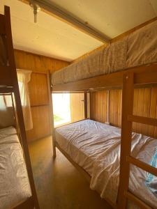 a bedroom with two bunk beds and a window at Coco y Ainhoa Lodge in Paracas