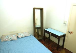 a bedroom with a bed and a table and a mirror at Cosy place at Serimaya condo in Kuala Lumpur
