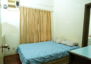 a small bedroom with a blue bed and a window at Cosy place at Serimaya condo in Kuala Lumpur