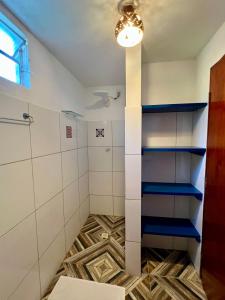 ein Badezimmer mit einer Dusche und blauen Regalen in der Unterkunft Casa Cristal in Jericoacoara