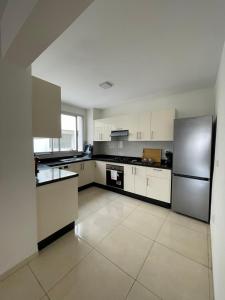 a kitchen with white cabinets and a stainless steel refrigerator at Beach & Pool - Adan Beach in Aourir